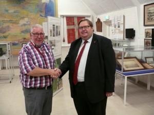 Viceborgmester S├©ren Rasmussen overr├ªkker den glade nyhed til museets formand, Kaj G. Nielsen